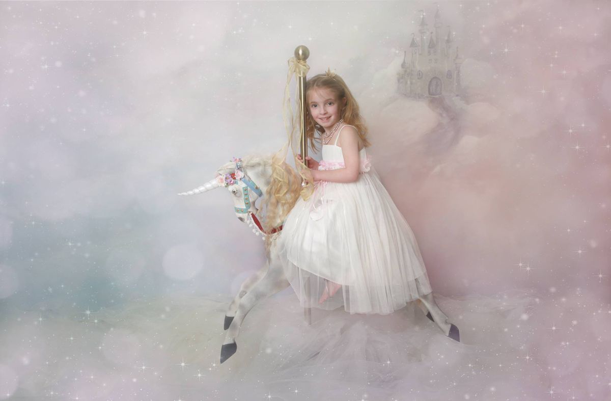 Girl sitting on a unicorn prop during the Mermaids and Unicorns fantasy photoshoot at Oakley Studios, Luton