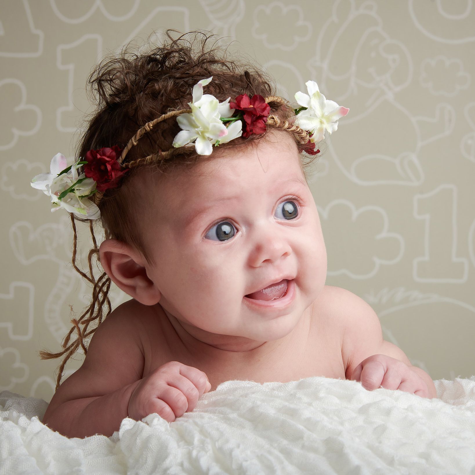 Baby girl wearing a delicate flower crown during a professional baby photoshoot at Oakley Studios near Luton and Dunstable border