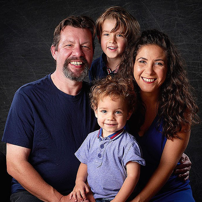 A man and woman are posing for a picture with two children.