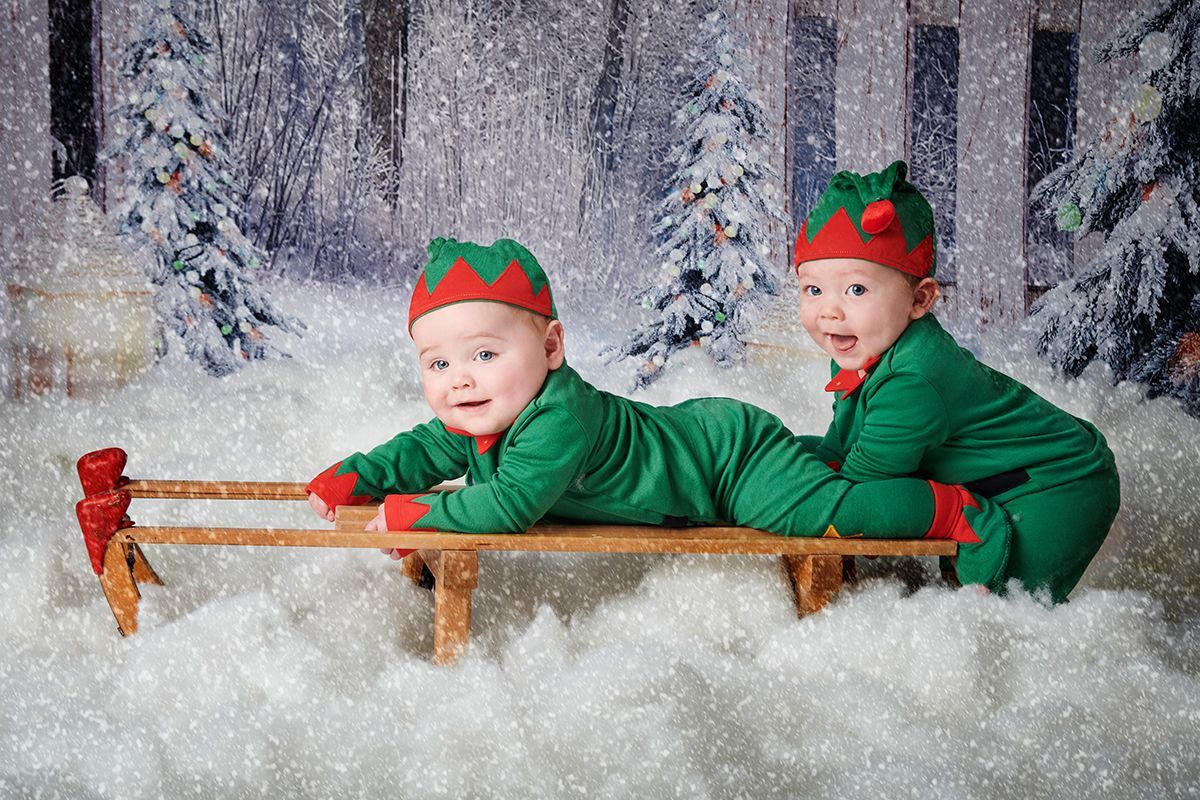 Twin children in a Christmas snow scene during a festive photoshoot at Oakley Studios, Bedfordshire