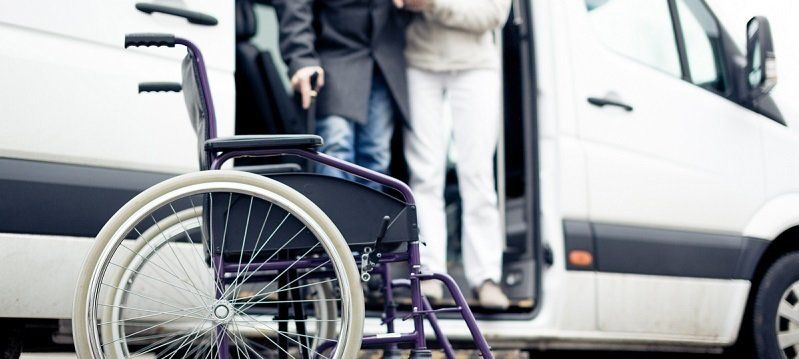 a person in a wheelchair is getting out of a van .