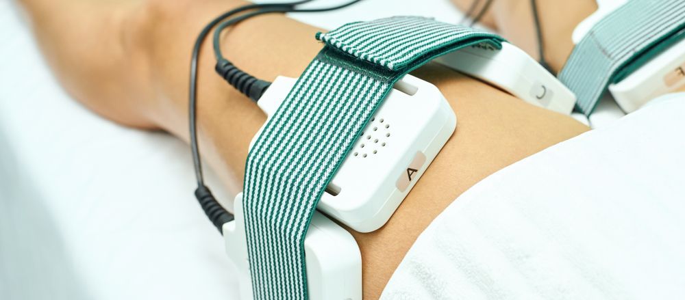 Blood pressure cuff strapped to a forearm with tubing attached