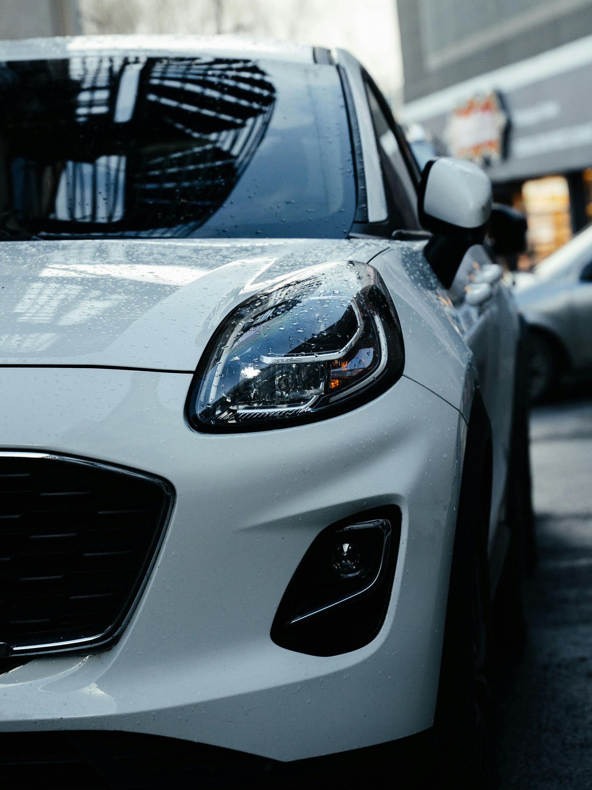 Front view of a white sports car parked on a city street