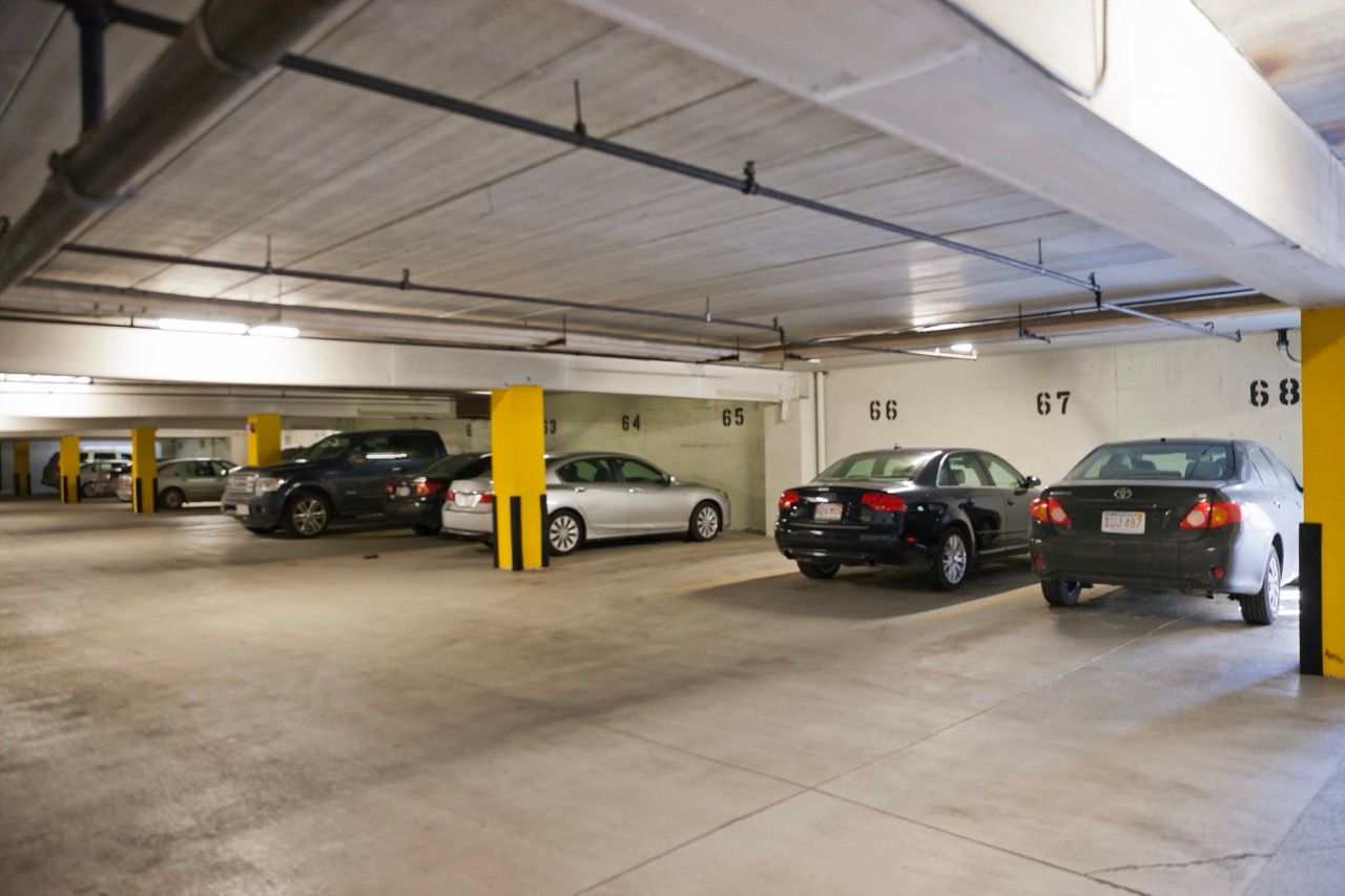 Indoor parking garage with numbered spaces and yellow support columns.