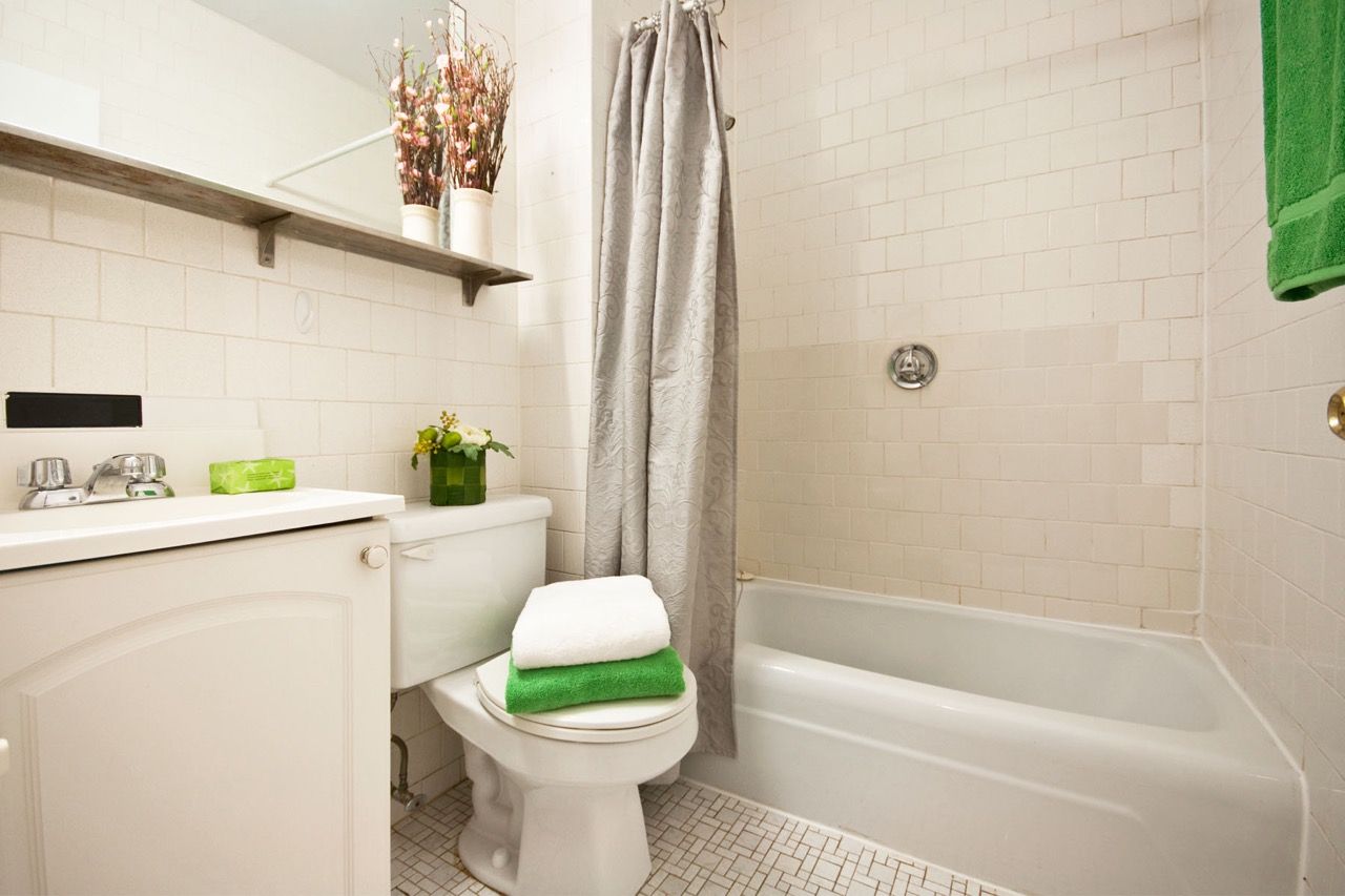 Bathroom with sink, toilet, shower curtain, and bathtub.