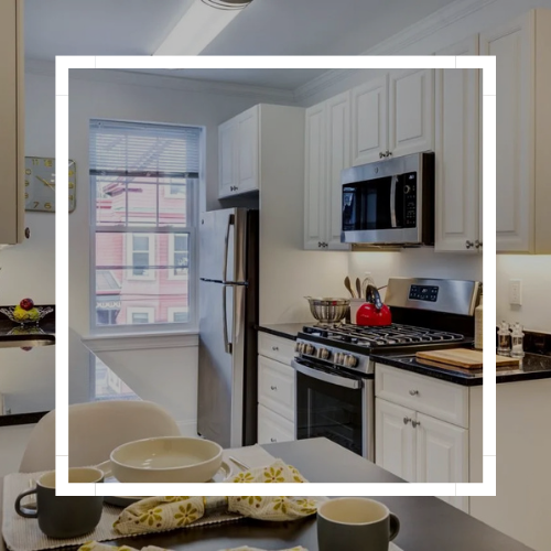 Bright white kitchen with stainless-steel appliances and a window over the sink.