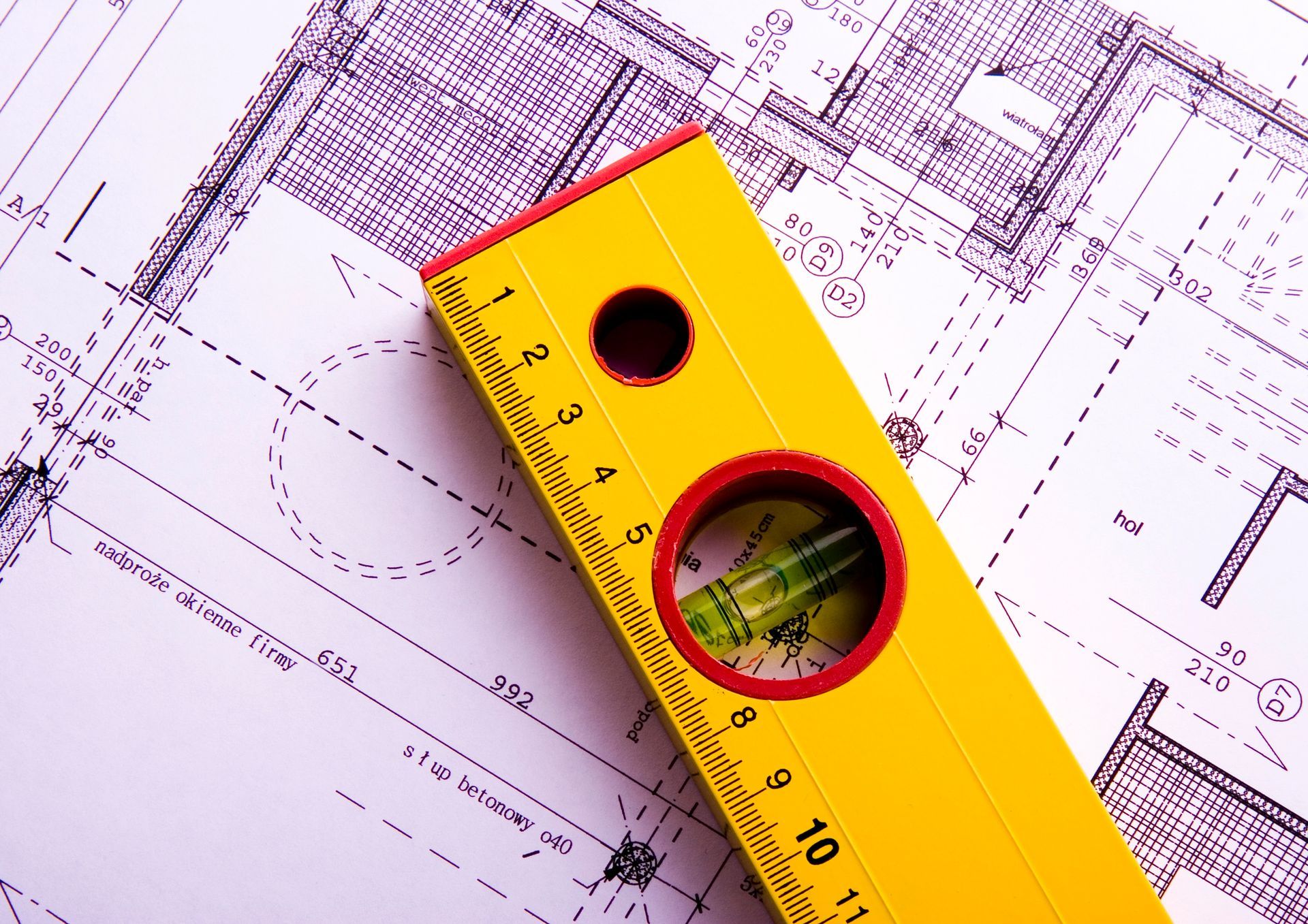 Livella a bolla gialla su planimetrie architettoniche e strumenti di misurazione