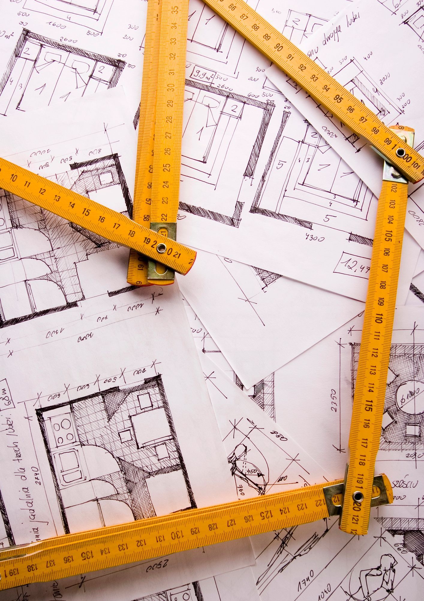 Righelli gialli su planimetrie e progetti architettonici.