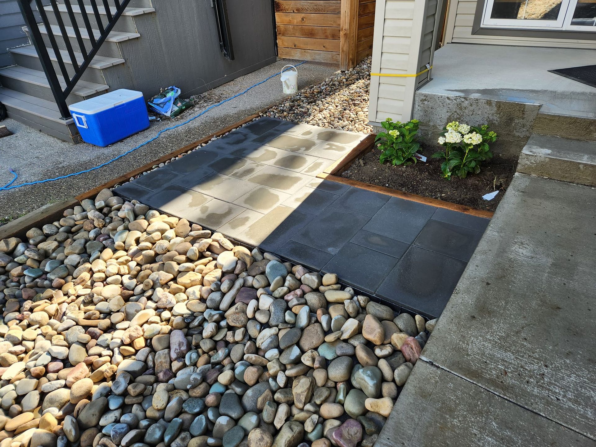A stone path featuring black and tan square pavers.