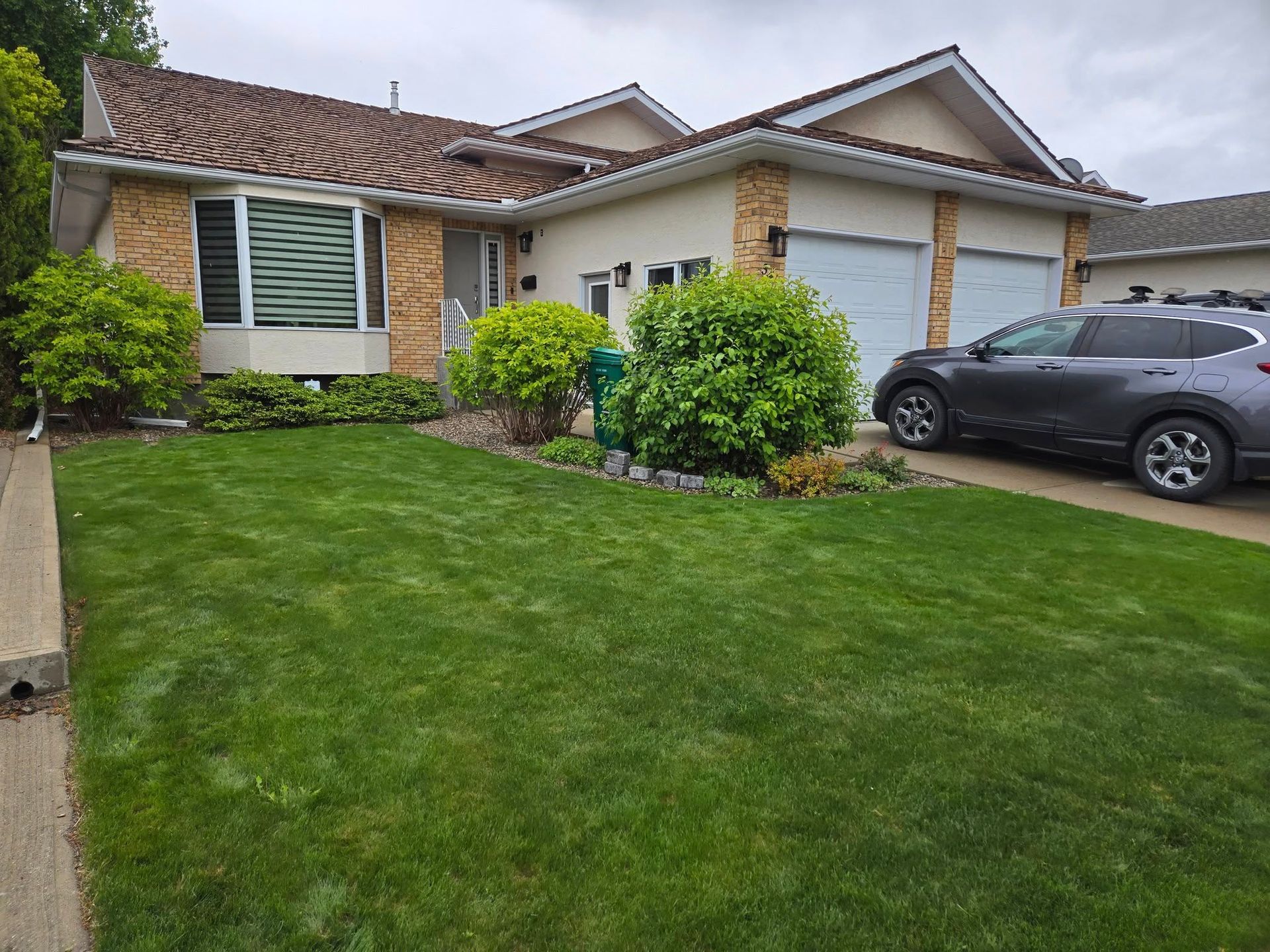 Green front lawn with bushes.