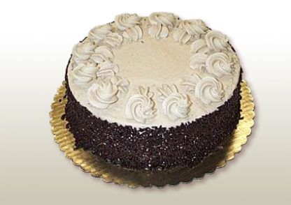 Chocolate cake with white frosting swirls and chocolate sprinkles.