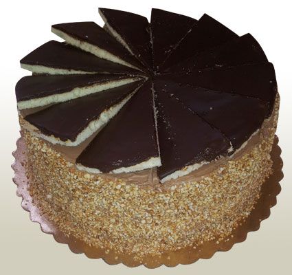 Chocolate cake with chocolate ganache topping, frosted with nuts, and sliced.