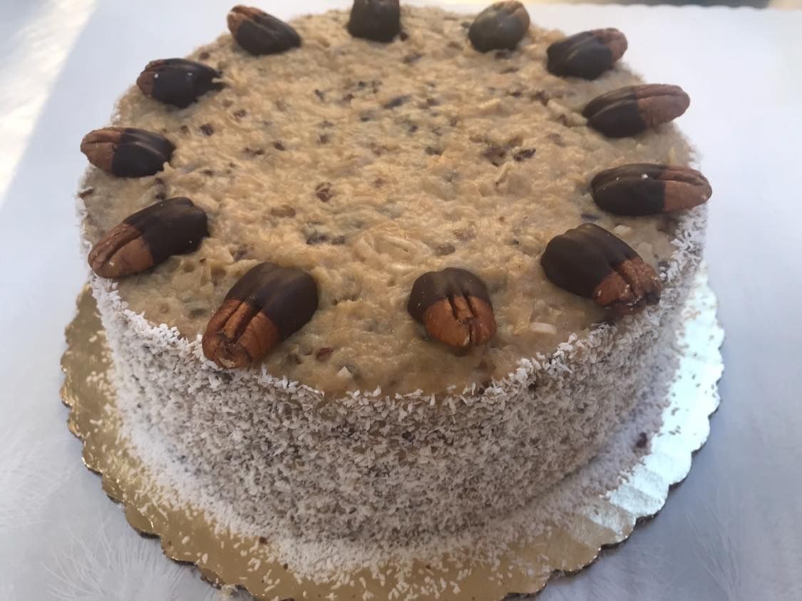 German chocolate cake topped with chocolate-covered pecans and shredded coconut frosting.