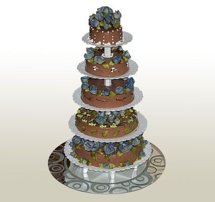 Five-tiered chocolate cake decorated with blue flowers, sitting on silver cake stands, on a reflective surface.