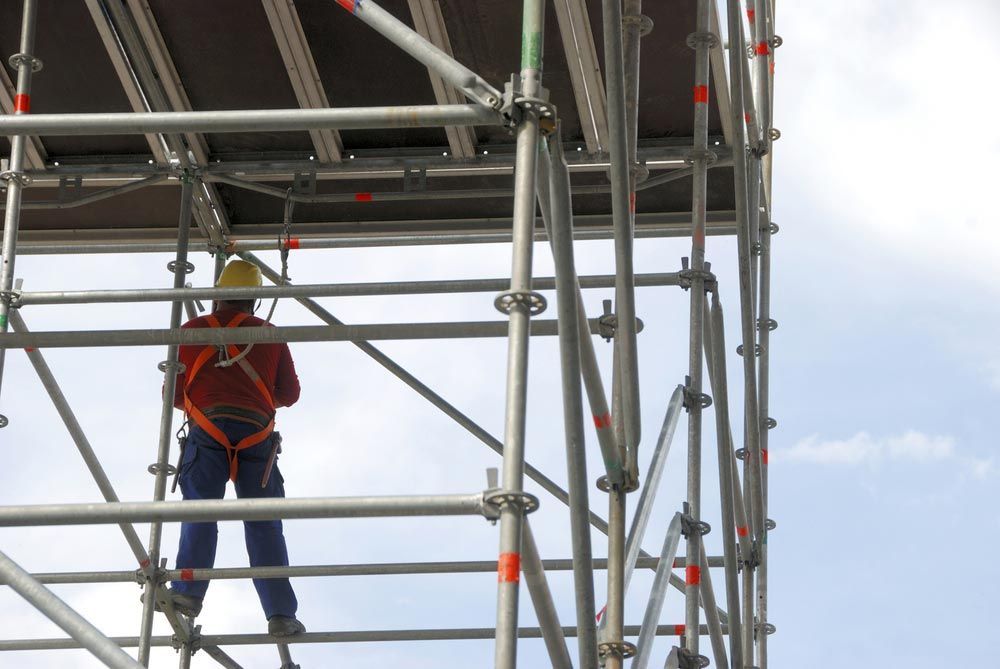 A Man Is Standing On Top Of A Scaffolding Structure — Triple S Scaffolding In South West Rocks, NSW