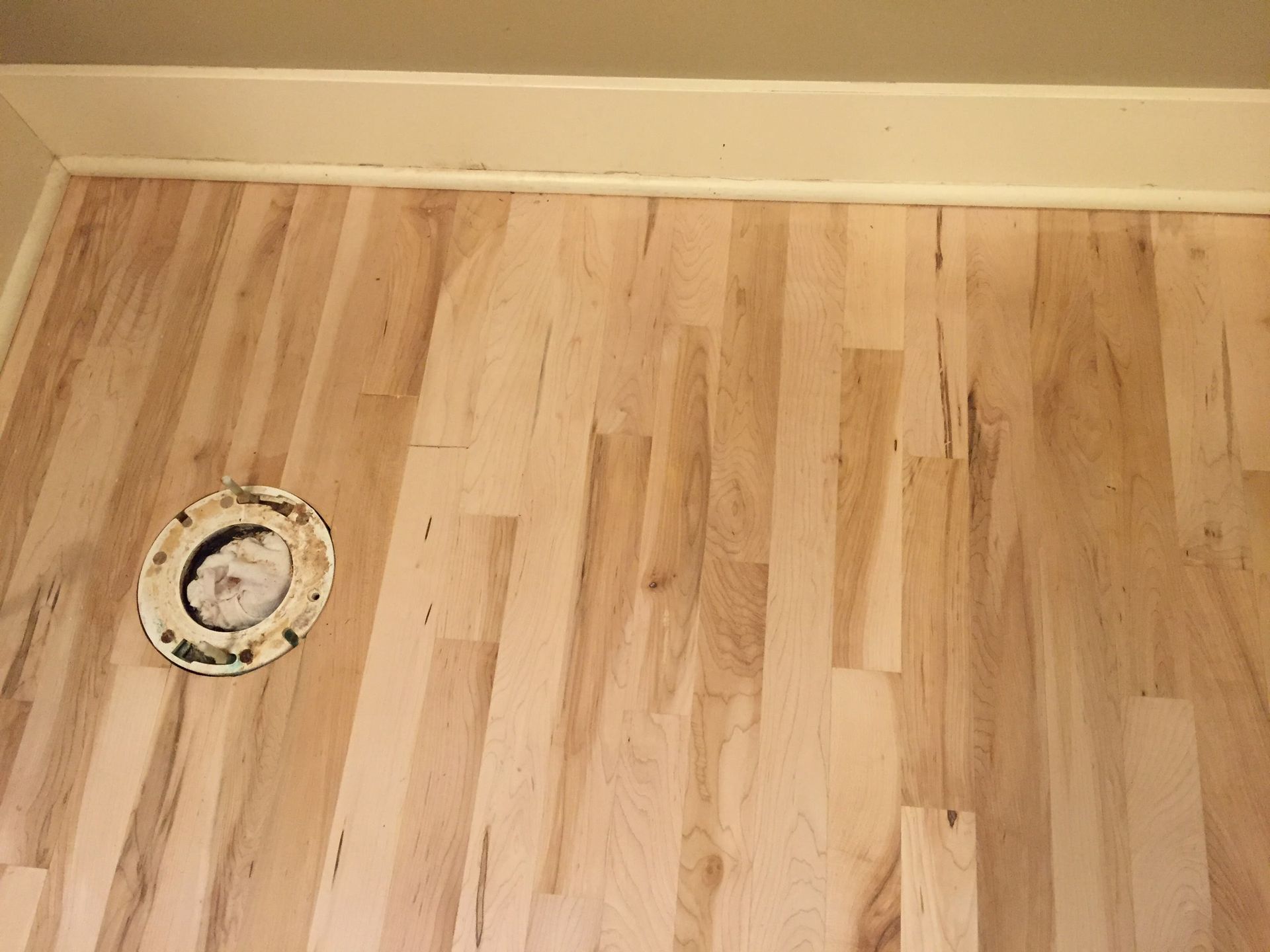 Light wood floor with a circular floor vent near the left wall.