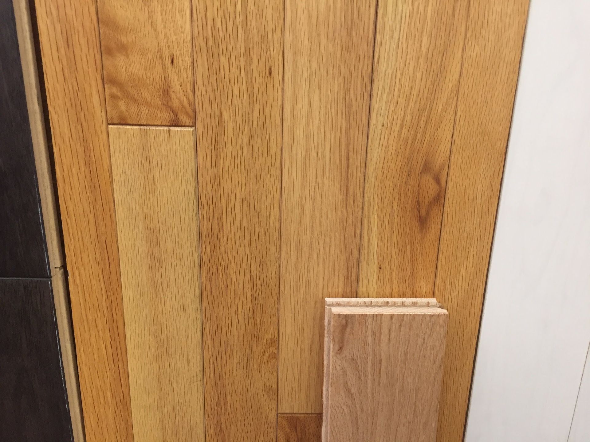 Close-up of wooden door panels with a light wood latch or block near the bottom right.