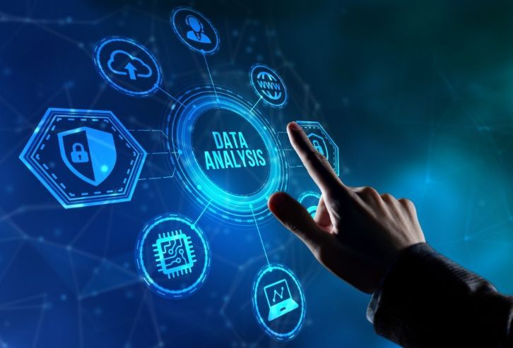 Hand touching a blue data analysis interface with icons like cloud, shield, and chip.