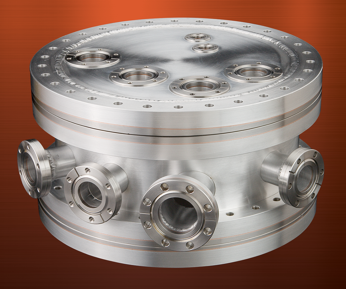 A cylindrical aluminum vacuum chamber with multiple bimetal aluminum/stainless flanges welded on the sides and top.