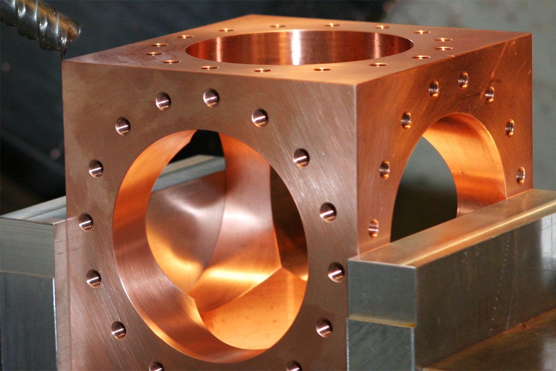 Custom square copper chamber being machined.
