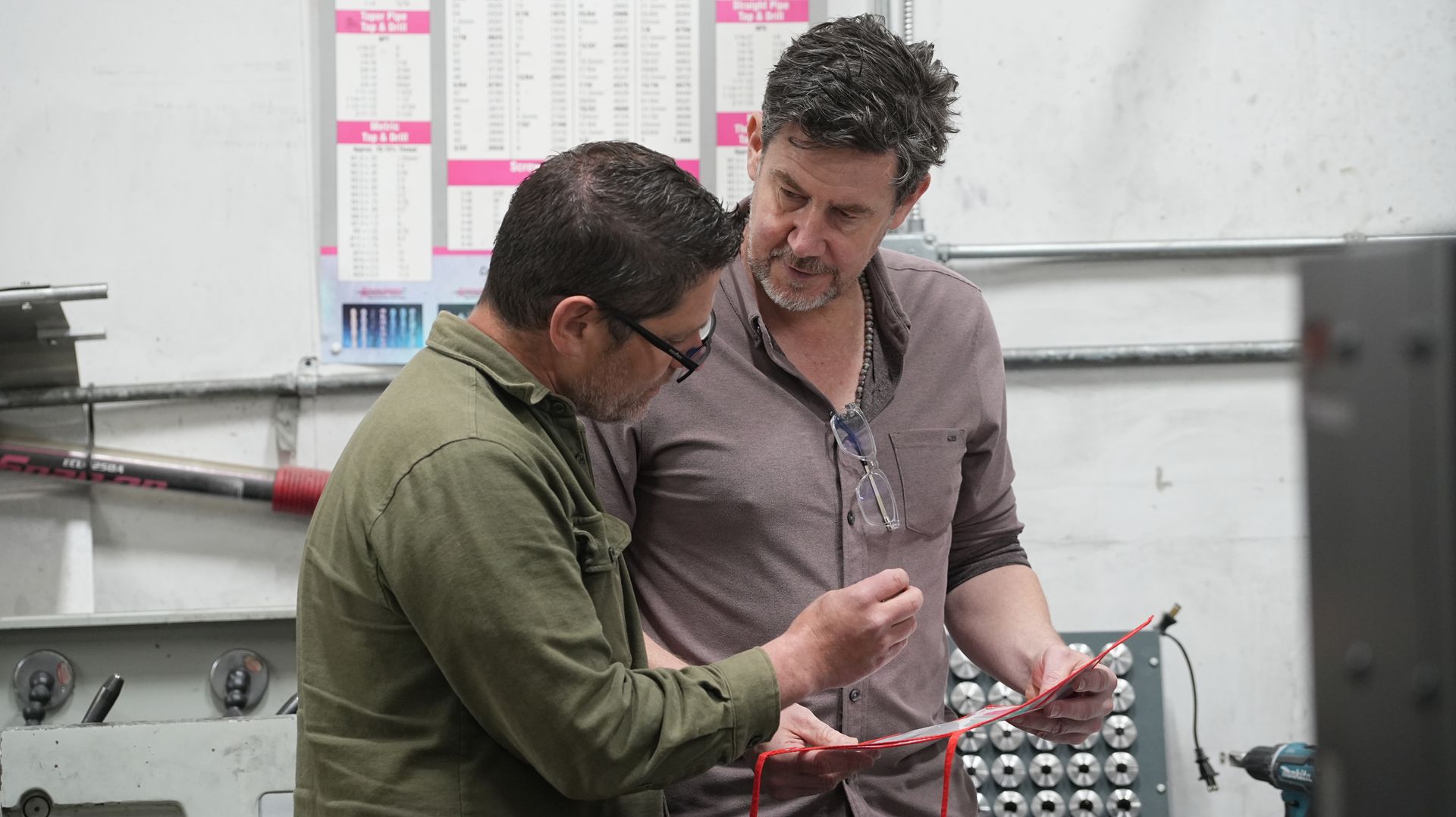 Atlas CNC programmer holds a work order and discusses it with Atlas owner Jed Bothell. 