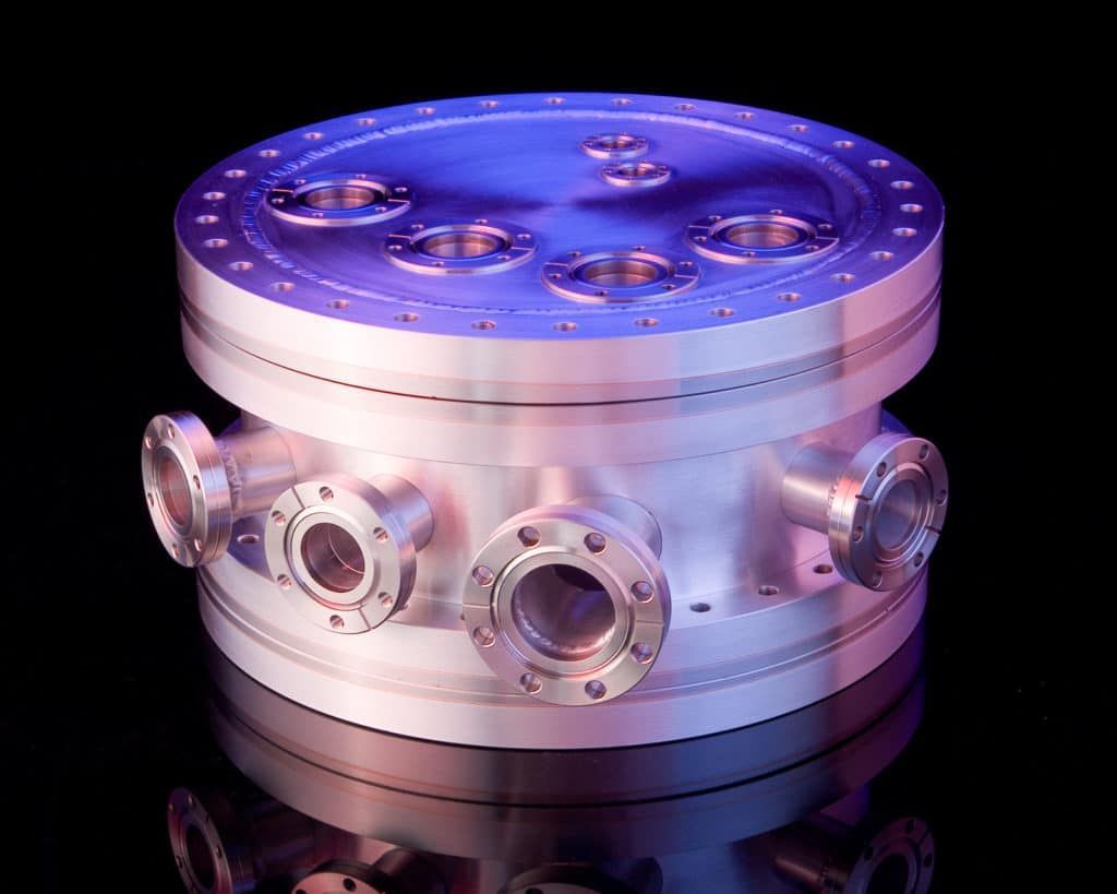 A cylindrical aluminum vacuum chamber with multiple bimetal aluminum/stainless flanges welded on the sides and top.