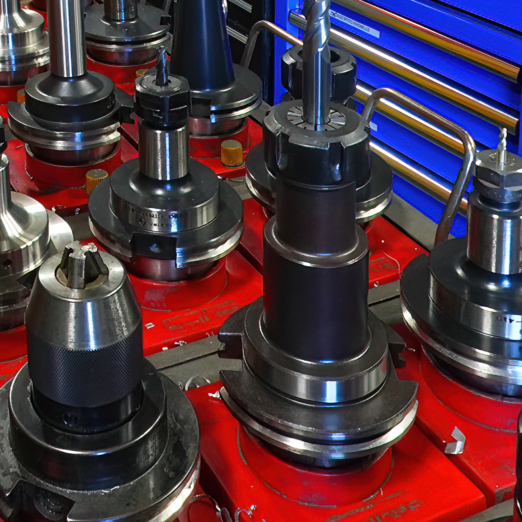 50 taper tool holders for CNC milling machine. on red bench.