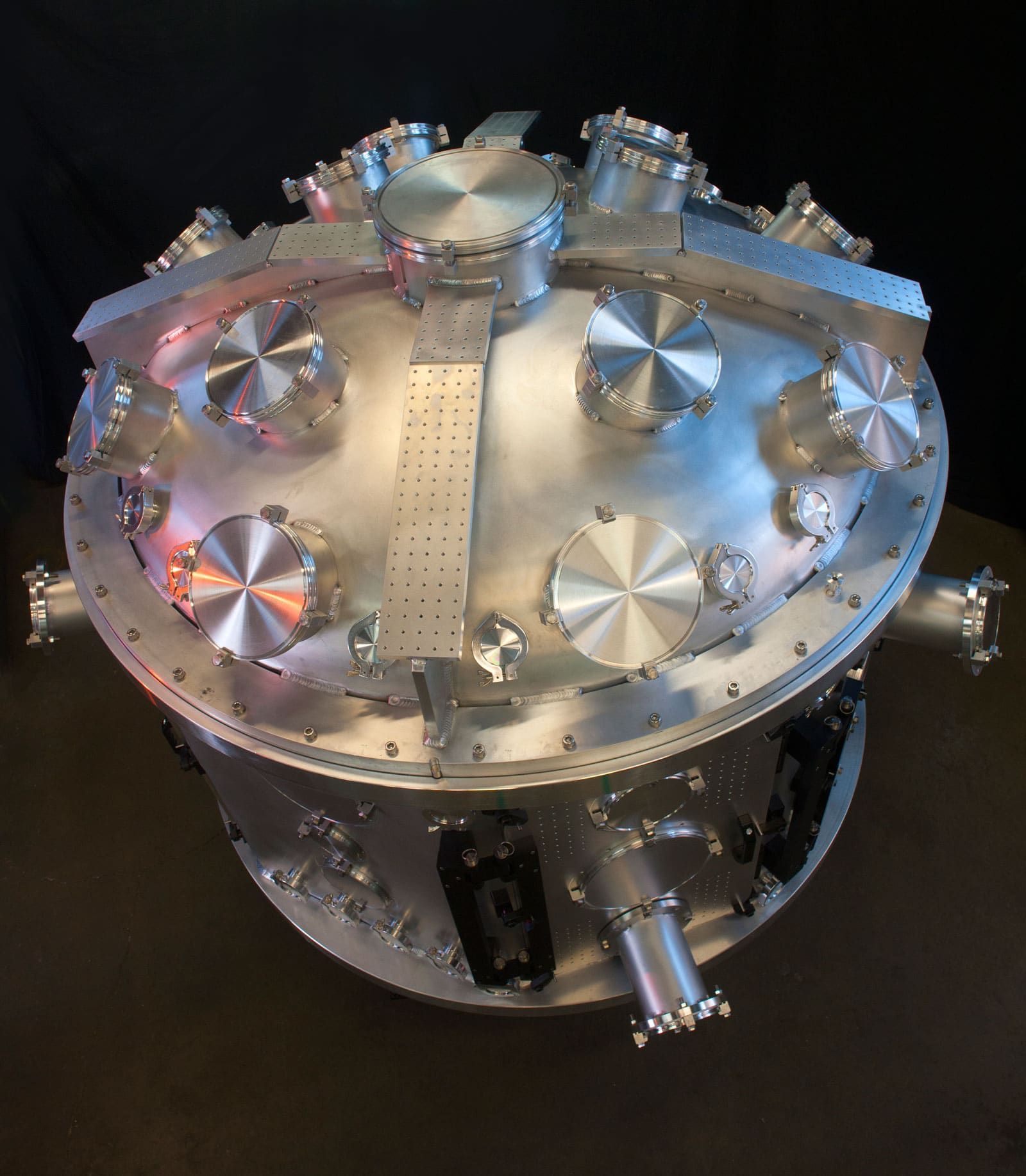 A close up of the top of a 5' diameter, aluminum vacuum chamber with targeting ports for laser experiments.