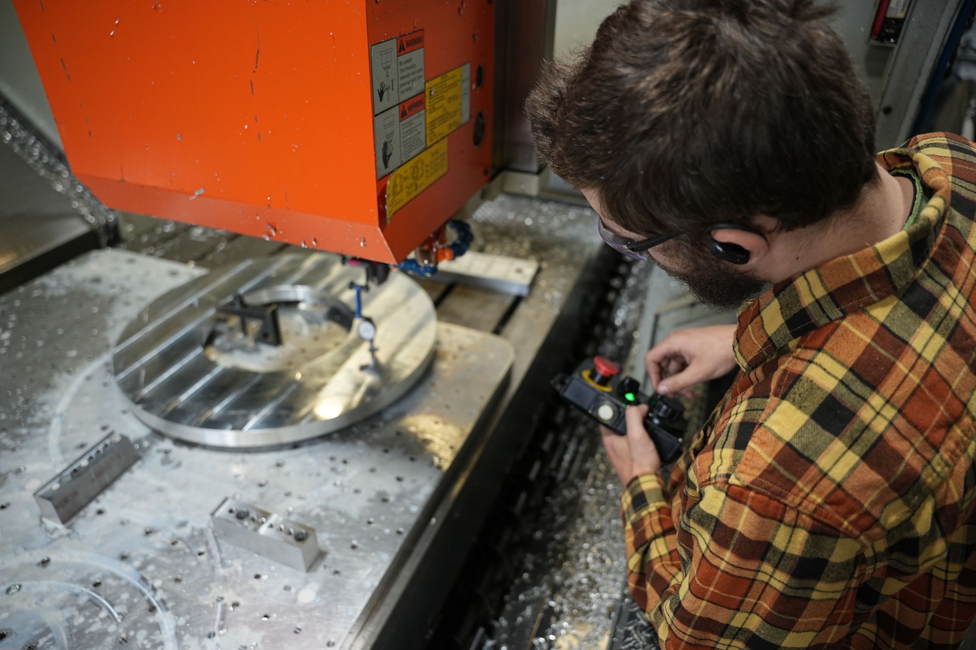 A man is calibrating a cutting machine in a factory.