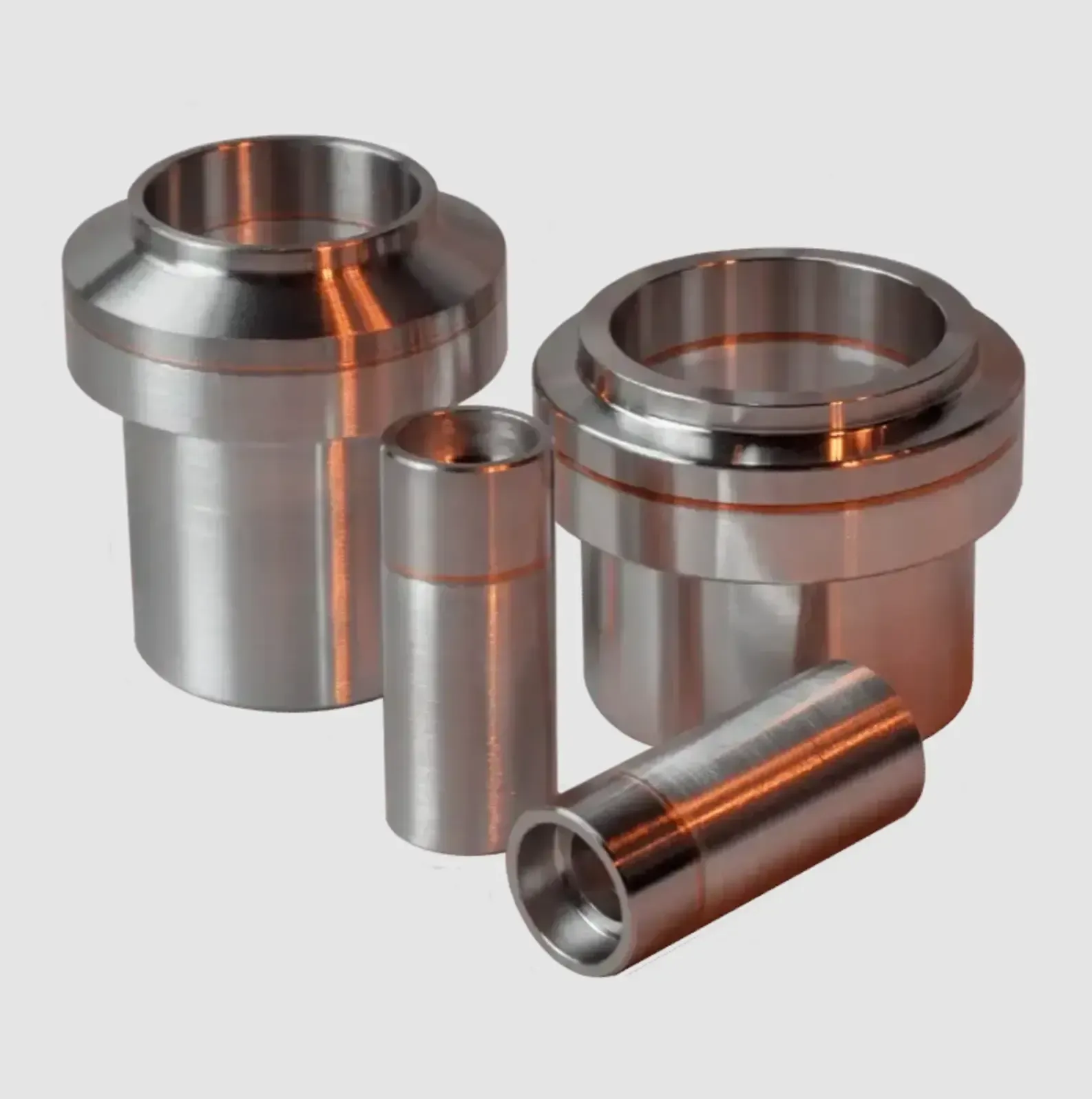 Three bimetal Al-SS fittings in different sizes and configurations are cylinder shaped with larger diameter endfaces.