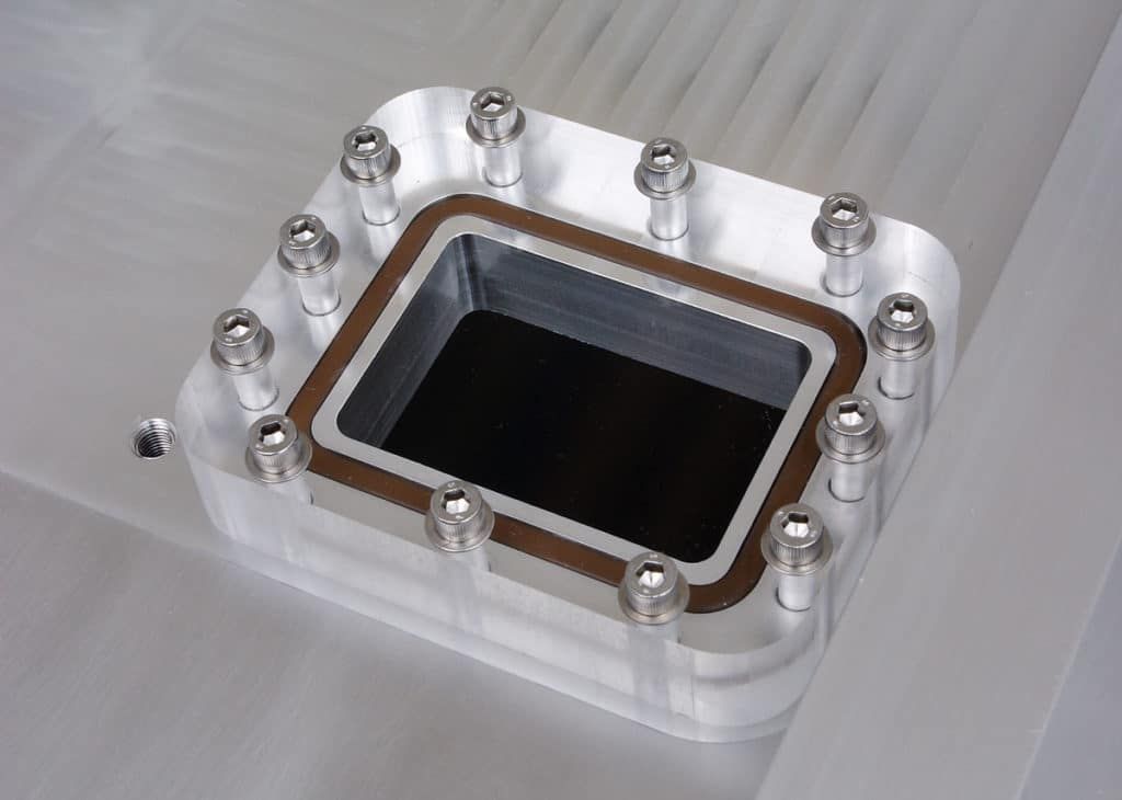 Polycarbonate vacuum-tight window installed on an aluminum chamber.