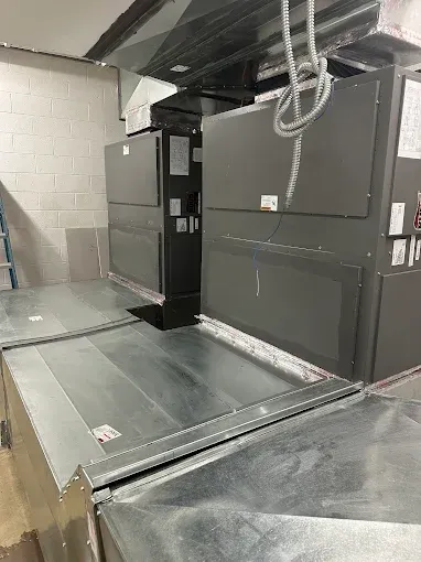 HVAC units inside a building, with metal ductwork.