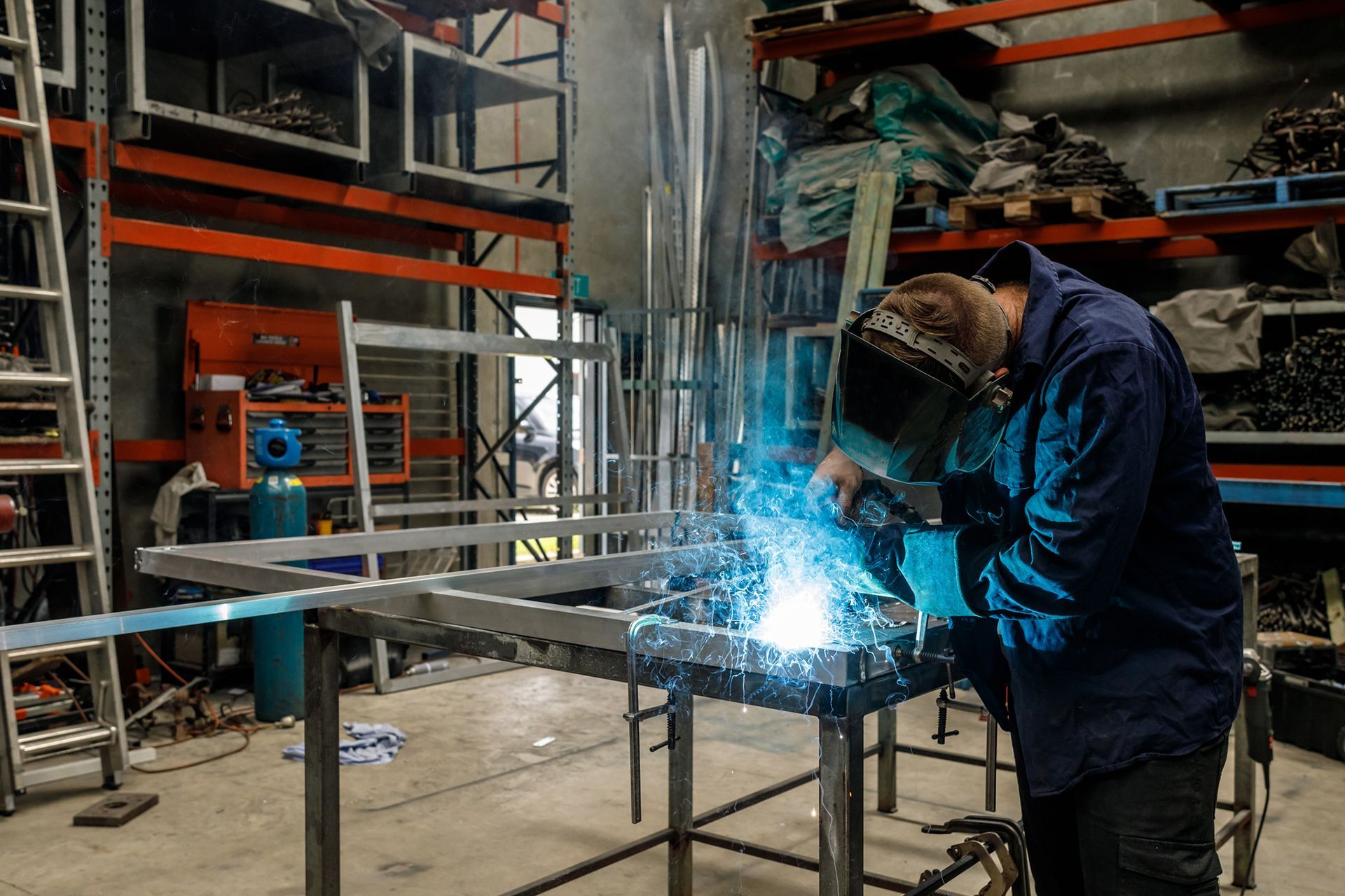 A young Australian apprentice metal worker welding in a factory.