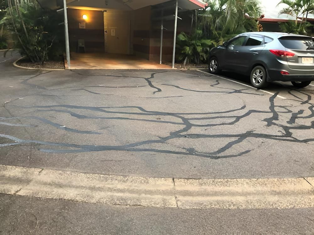 A Car is Parked in a Parking Lot in Front of a House — F & J Bitumen Services in Humpty Doo, NT