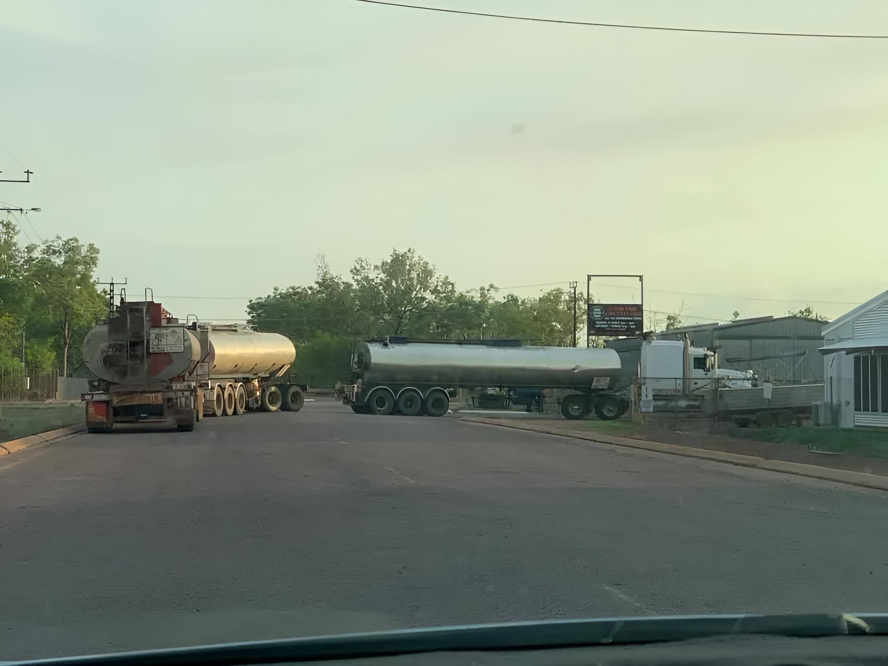 A Tanker Truck is Driving Down the Road Next to Another Truck — F & J Bitumen Services in Humpty Doo, NT