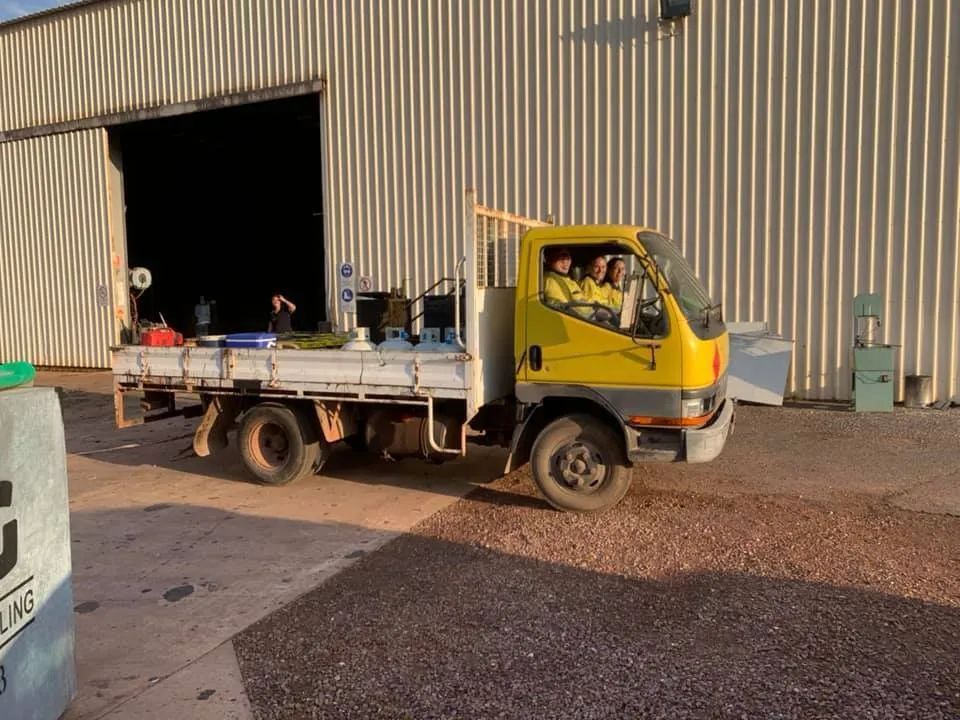 A Yellow Truck is Parked in Front of a Building — F & J Bitumen Services in Humpty Doo, NT