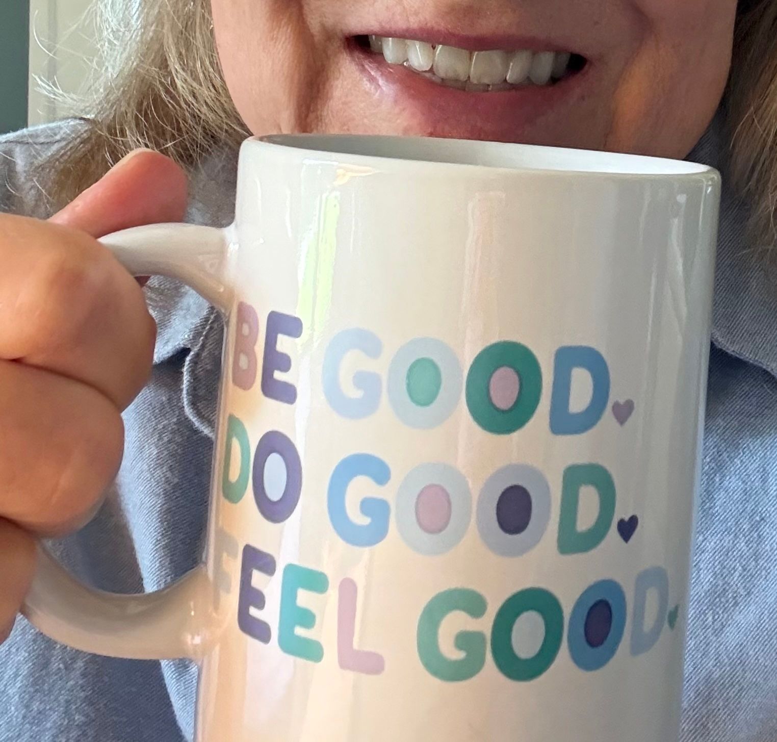 Smiling woman with white coffee mug that says 