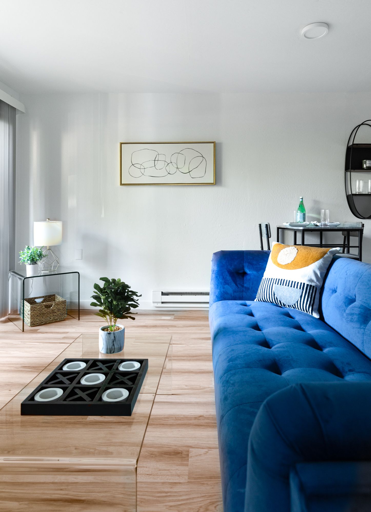 Bright living room with a blue sofa, wooden coffee table, and minimalist decor.