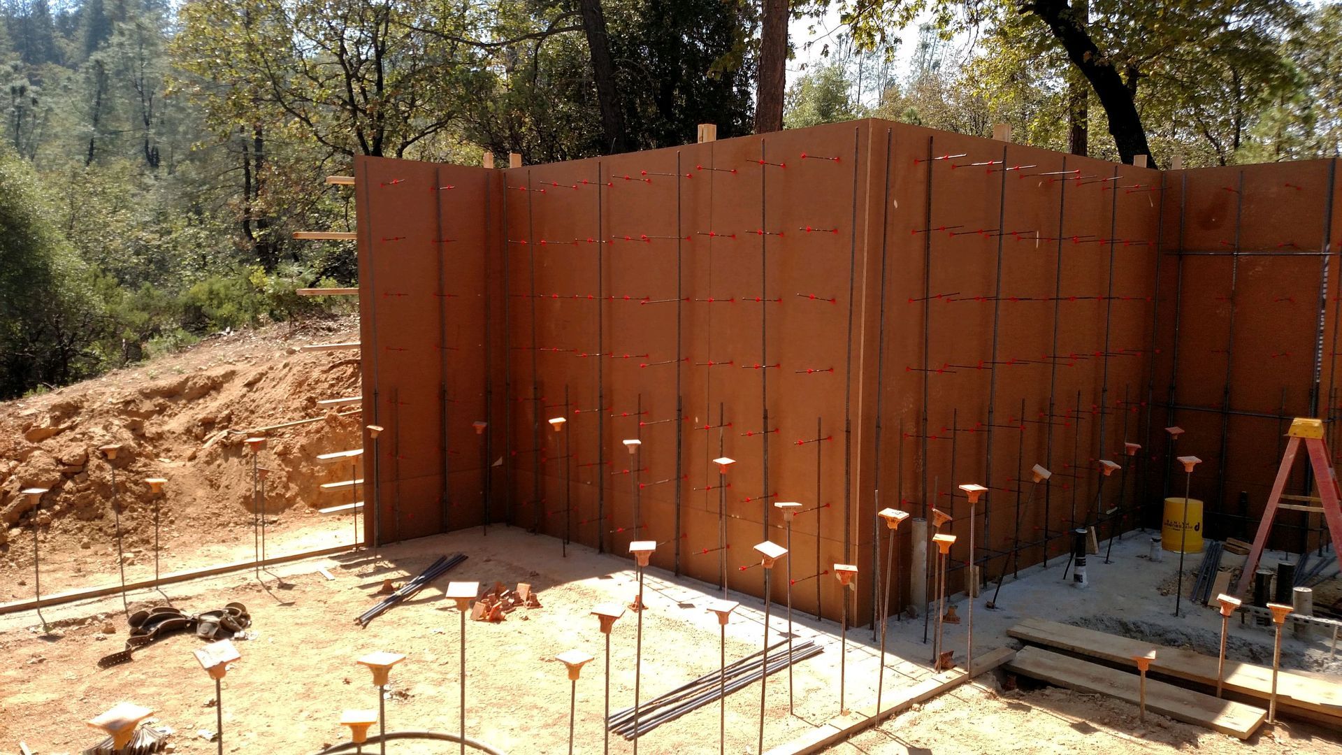 A large wall is being built in the middle of a construction site