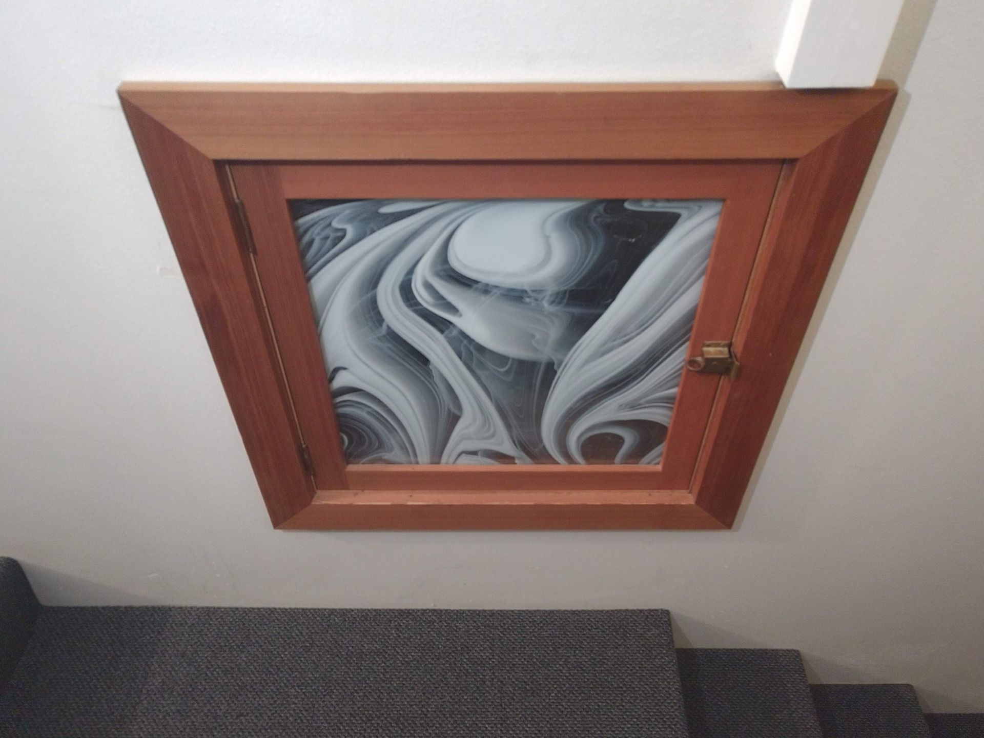 A staircase with a picture on the wall above the stairs