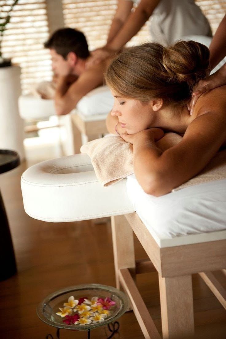 Un hombre y una mujer están recibiendo un masaje en un spa.