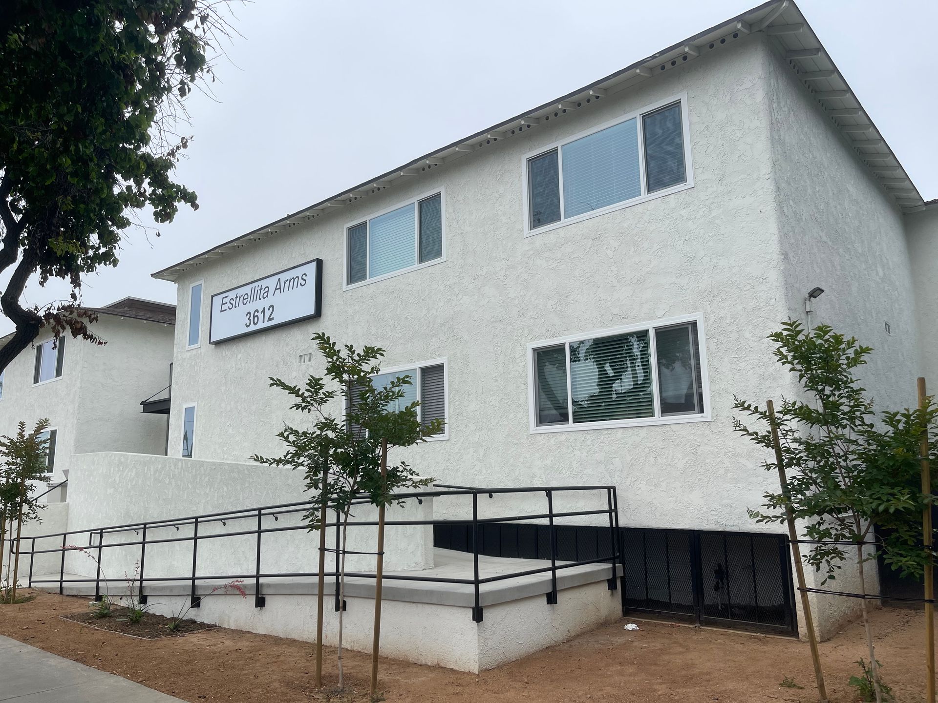A white apartment building with a handicap ramp