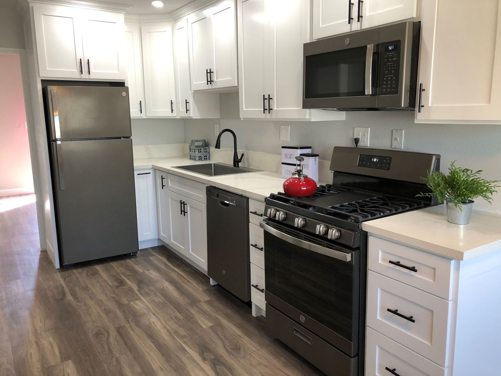 A kitchen with stainless steel appliances and white cabinets