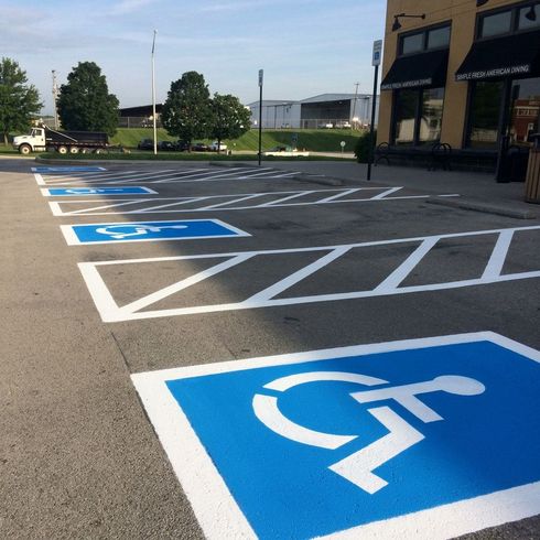 Professional parking lot striping at a gas station with clear yellow lines and numbered spaces