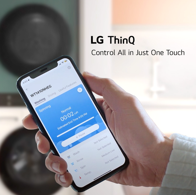 Hand holding a phone displaying LG ThinQ app, controlling appliances with one touch.