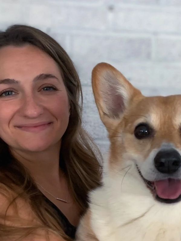 A woman is posing for a picture with her dog.