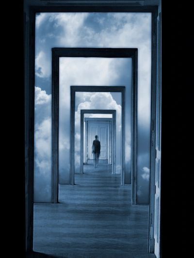 endless doors A man is walking through a row of doors in the sky