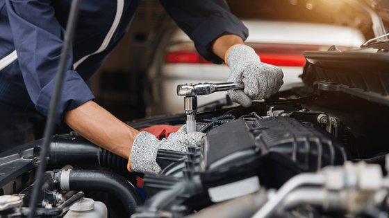 a mechanic doing an auto repair with a wrench
