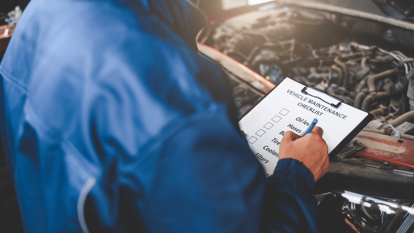 a mechanic holding a clipboard during a vehicle inspection