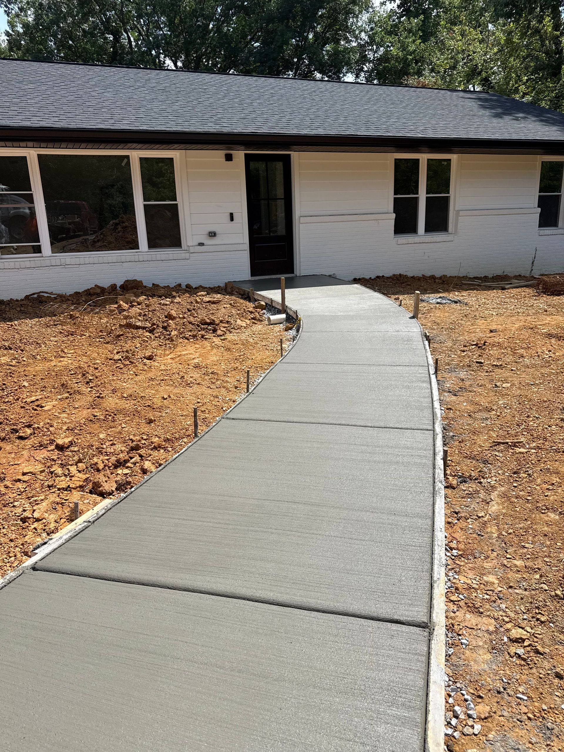 A group of construction workers are working on a concrete walkway.